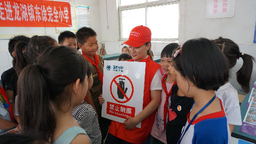該公司黨員服務(wù)隊(duì)隊(duì)員孟姍姍在為孩子們講解安全標(biāo)志